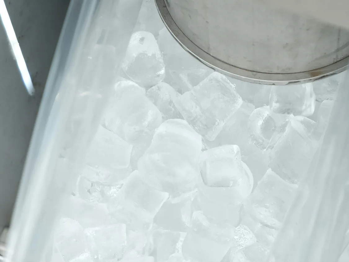 Ice cubes and a scoop in a commercial ice machine bin — commercial ice machine repair